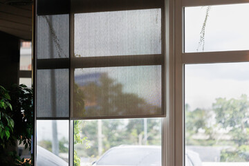 Fototapeta na wymiar black blind curtain decoration near white frame window in office.