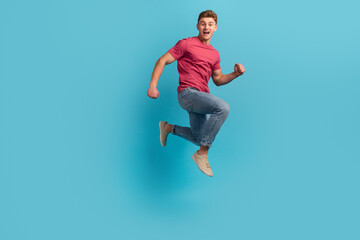 Fototapeta na wymiar Full body profile side photo of young excited man run jump hurry activity isolated over blue color background