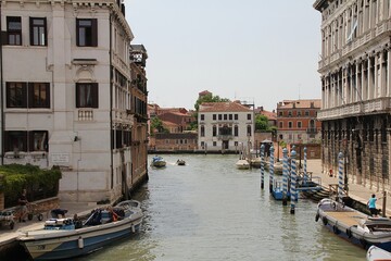 Venice, blue and white posts in the Venice water canal, water canal, classical architecture, boats parked along the canal