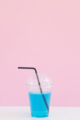 Fresh lemonade cocktail on color background. Cocktail in plastic cup