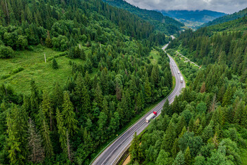 red cargo truck on the higthway. cargo delivery driving on asphalt road through the mountains. seen...
