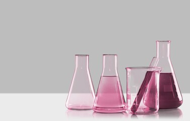 Glass laboratory equipment filled with fluid in a beaker test tube in lab background for experiment...