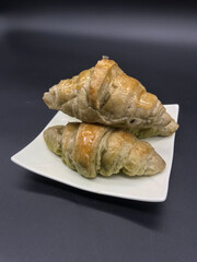 Croissant on a white plate on a black background,Include Clipping Path.