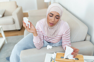 Sickness, seasonal virus problem concept. Arabic woman being sick having flu lying on sofa. Sick...