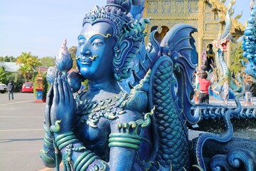 Closeup of blue buddha statue in prayer pose
