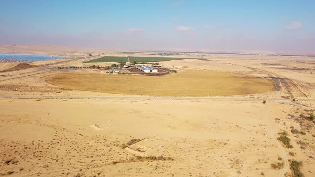 Rising up over the farm in desert Negev with large a cow barn at sunny morning