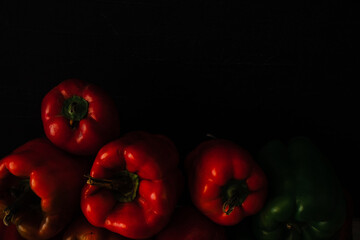 Few fresh red green paprika on a black background