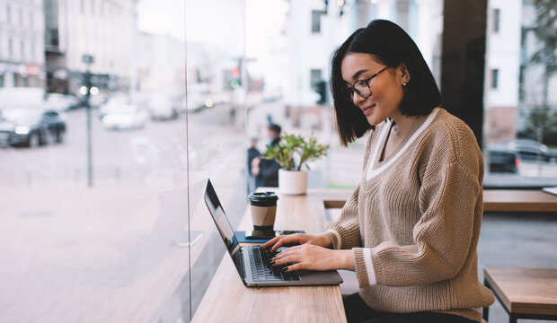 Young millennial asian girl working in cafe