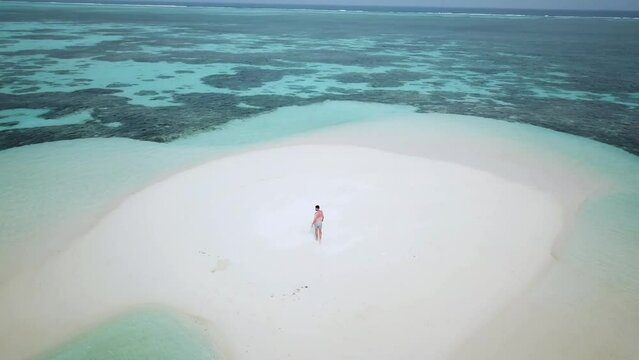 Aerial drone video of me walking on a sandbar in Maldives. Yellow kayak parked on a sandbar in Indian ocean. Activity combined with Relax in Maldives. Turquoise calm sea. Kayaking in paradise. 
