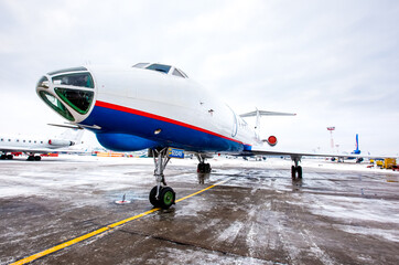 Naklejka premium Airplane front fuselage with blue sky. Aircraft on runway of airfield