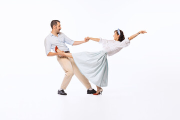 Portrait of young beautiful couple, man and woman, dancing rock and roll isolated over white studio...