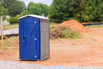 Portable restroom near construction site is being used by workers