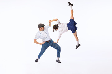 Fototapeta na wymiar Portrait of cheerful couple, man and woman, dancing boogie woogie isolated over white studio background