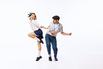 Portrait of beautiful couple, man and woman, dancing retro dance isolated over white studio background