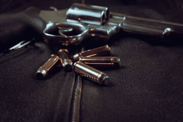 .44 magnum revolver and ammunition on a leather background biker jacket