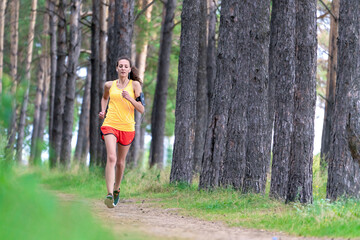 Running woman. Female runner jogging at the park. Girl training outdoors. Exercising on forest...