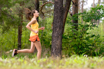 Running woman. Female runner jogging at the park. Girl training outdoors. Exercising on forest...