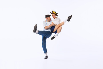 Portrait of beautiful couple, man and woman, dancing retro dance isolated over white studio...