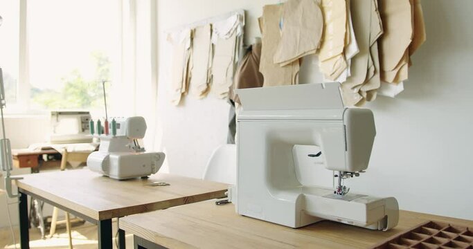 Tailor's workplace with sewing machine and patterns in atelier. Sewing business