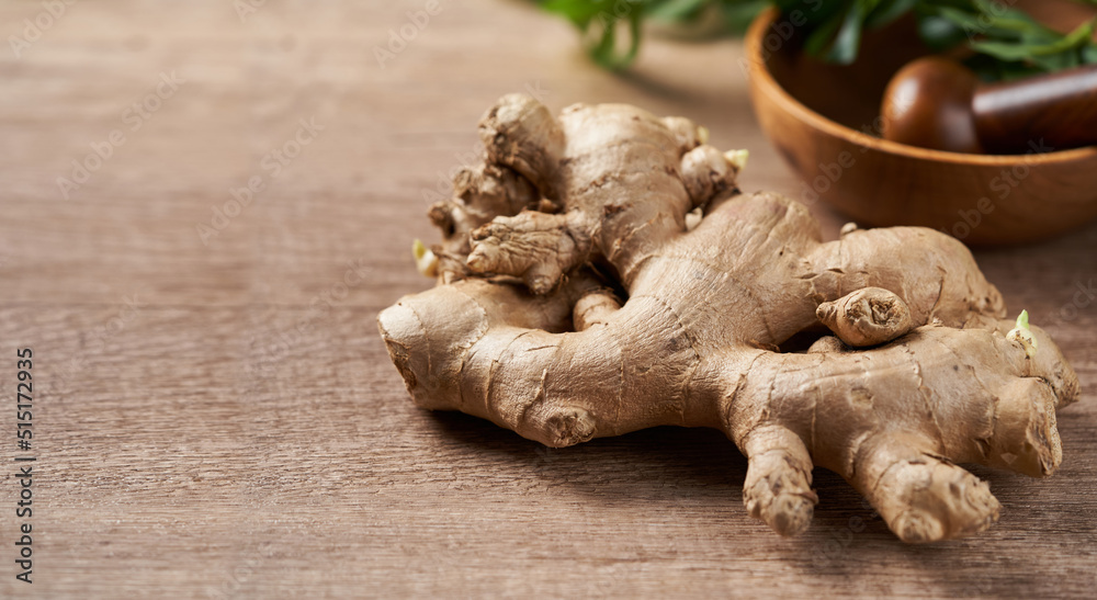 Wall mural ginger root and mortar on the wooden table background with copy space