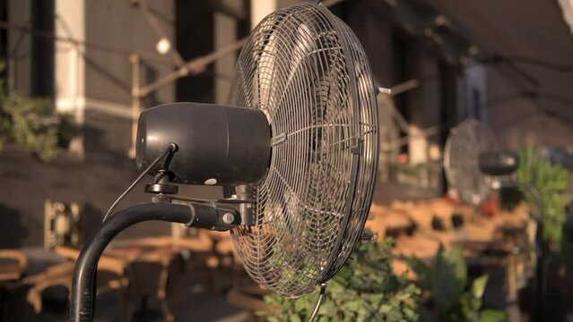 4k video with a fan cooling a terrace restaurant during a hot summer day