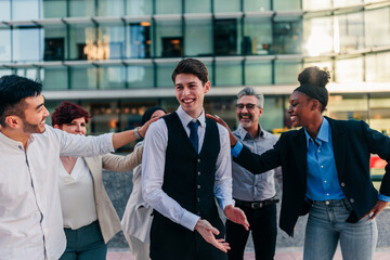 Diverse business people motivating young coworker