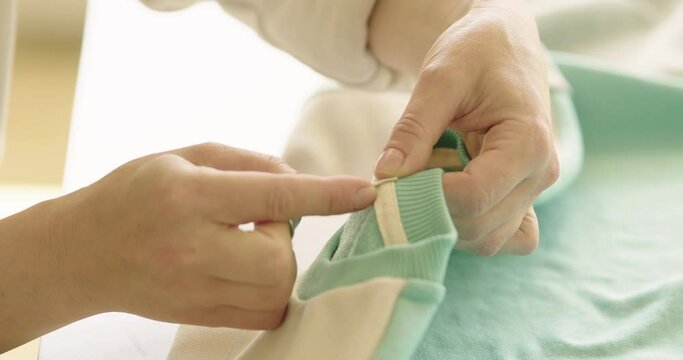Concentrated stylist tailor making last touches with needle and threads