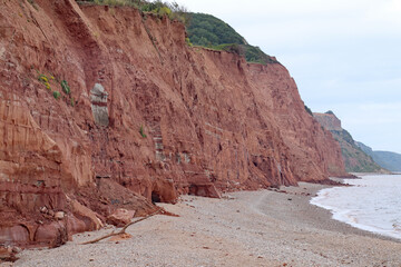 The red Jurassic cliffs by the east beach at Sidmouth, England. The cliffs suffer much erosion and the houses at the top keep losing sections of their gardens