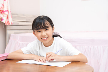 Fototapeta na wymiar 子供部屋で勉強をする小学生の女の子