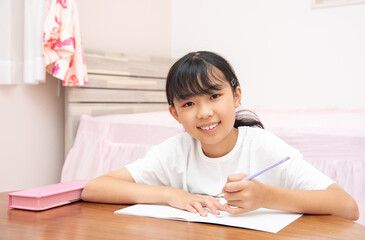 Fototapeta na wymiar 子供部屋で勉強をする小学生の女の子