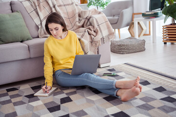 Full size photo of calm focused person sitting carpet hold pen take notes house indoors