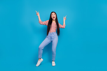 Full length photo of impressed funny lady dressed red shirt dancing pointing empty spaces isolated blue color background