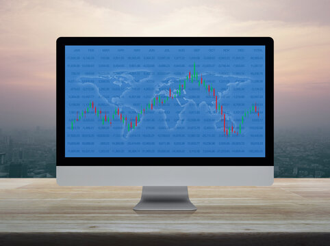 Trading graph of stock market with world map and graph on computer screen on table over city tower at sunset sky, vintage style, Investment online concept, Elements of this image furnished by NASA