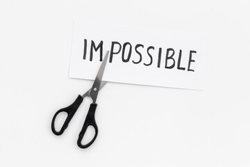 Change your life concept. Impossible cutting into Possible with scissors
