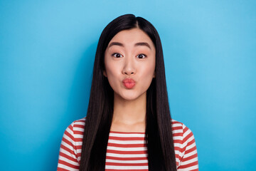 Fototapeta premium Photo of pretty positive vietnamese person kiss pouted lips look camera isolated on blue color background