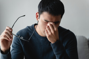 stressed man take off glasses massage eyes feel fatigue suffering from headache, exhausted man...