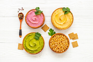Green and purple hummus with spinach and beets in bowls, top view