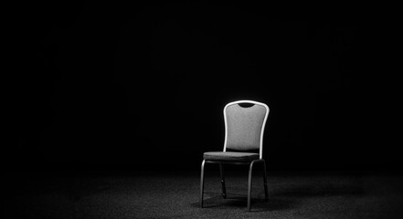 A chair in a black room. Chair on the stage for recording an interview or blog. Place for an interview