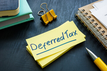 Deferred tax written on the sticker and papers. - obrazy, fototapety, plakaty