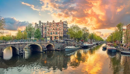 Foto op Aluminium Amsterdam. Panoramisch zicht op de binnenstad van Amsterdam. Traditionele huizen en bruggen van Amsterdam. Een kleurrijke zonsondergang. Vintage afgezwakt. © Taiga
