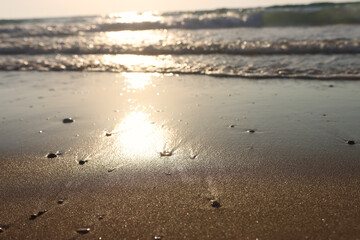 Sea waves and warm sunset light, calm and relaxing sandy beach