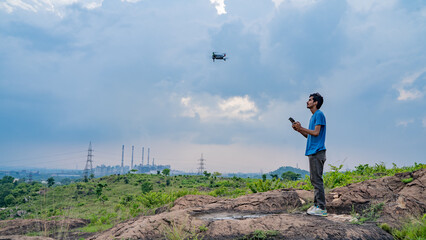 Young man flying drone, unmanned aerial vehicle, photographer, filmmaker or content creator concept