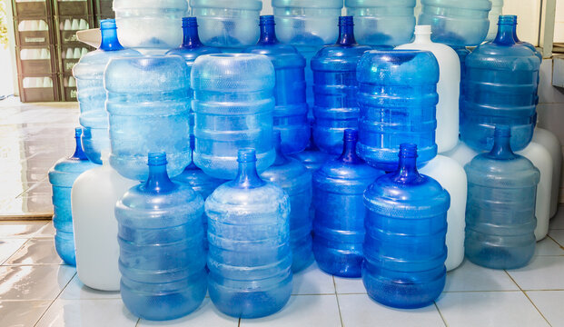 Blue plastic bottles or blue gallons of drinking water are stacked in the drinking water factory to cycle the drinking water.water factory  business concept