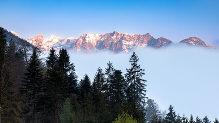 Alpenglühen an den Bergen um Berchtesgaden im Morgennebel