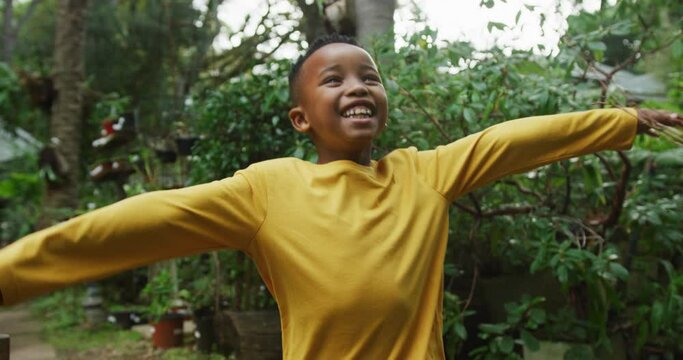 Happy african american boy running and playing in garden