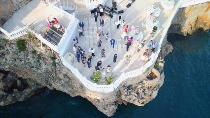 Top view of people celebrating wedding on the cliff. Drone aerial view