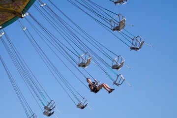 Teenage girl on chain swing carousel