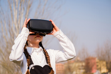 Little girl with virtual reality glasses. Future technology concept - Beautiful girl with virtual reality outdoor in a park