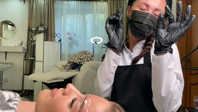 Master cosmetologist dances funny during permanent makeup of eyebrows