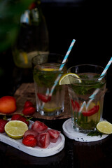 Colorful infused water with lemon, lime, mint and strawberries. Healthy natural summer cocktails. Refreshing, diet, detox, natural, fortified water. Hard zeltzer, nootropics. Summertime beverages.